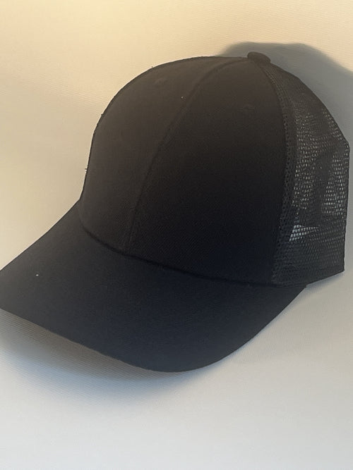 A black trucker-style baseball cap with a solid black front panel and brim, and black mesh back panels.