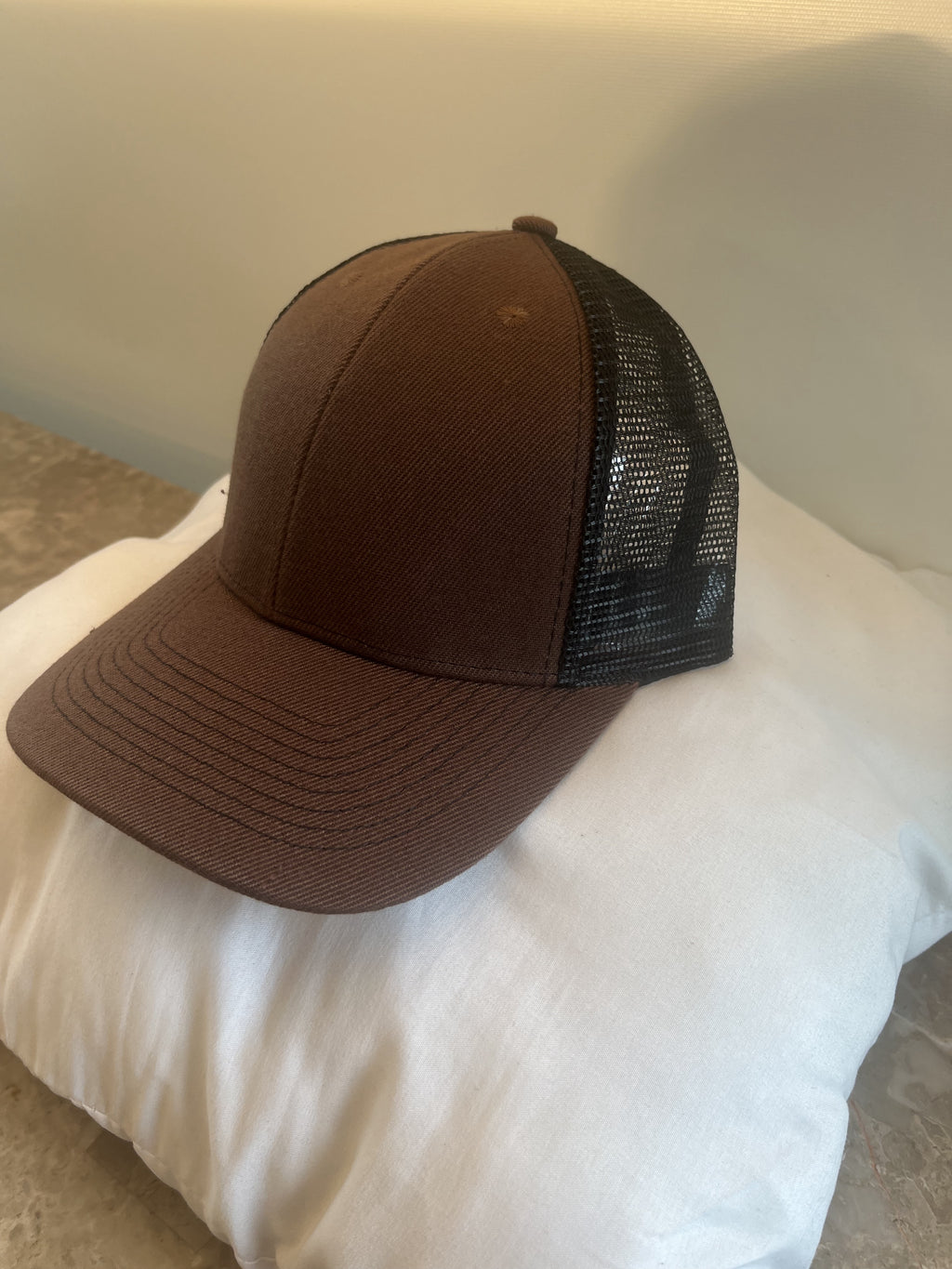A brown trucker-style baseball cap with a black mesh back.