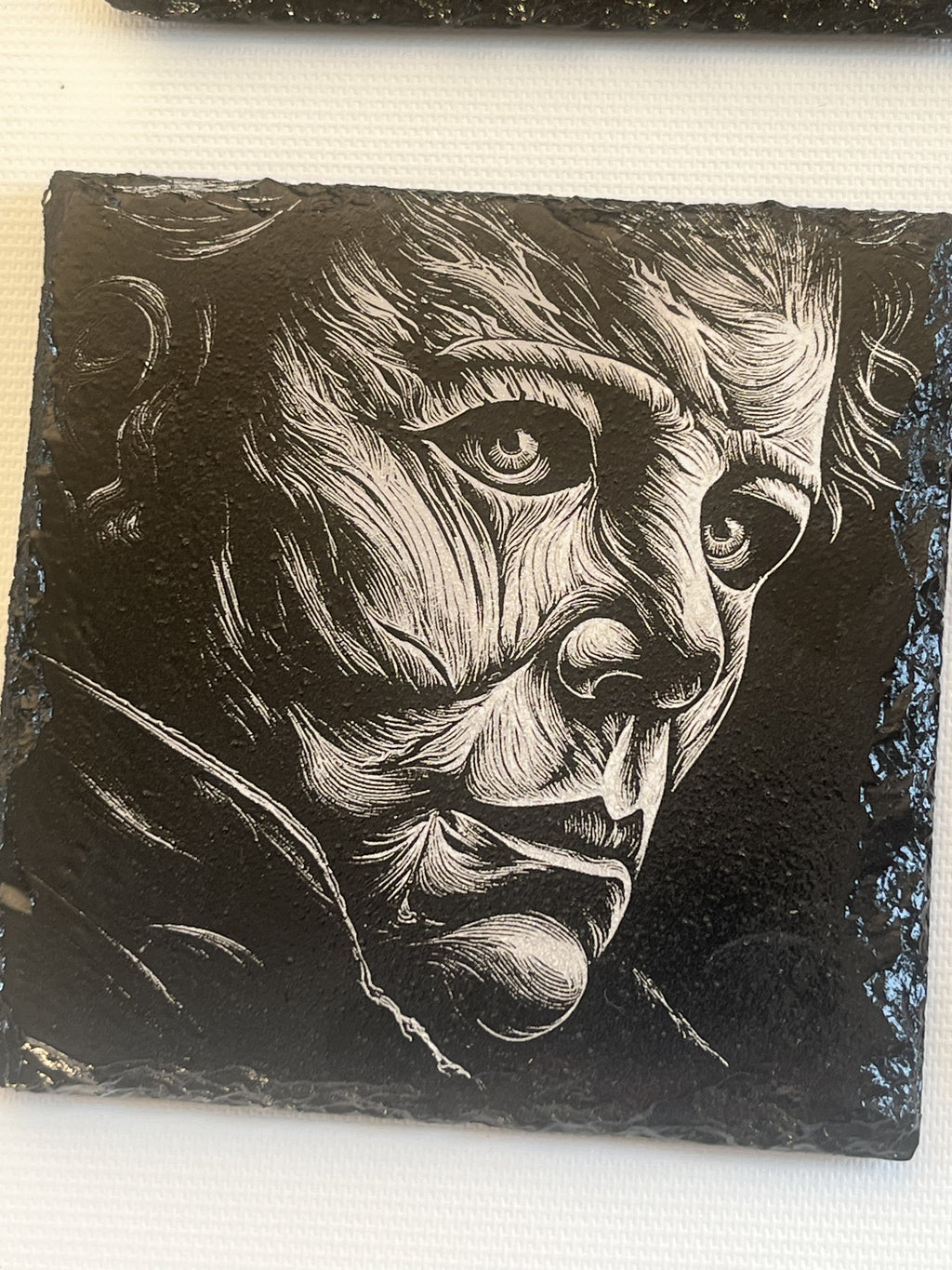 A square black slate stone coaster featuring a high-contrast black and white portrait of Michael Myers.
