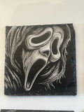 A square black slate coaster featuring a white and gray relief carving of the iconic Ghostface mask from the Scream franchise.
